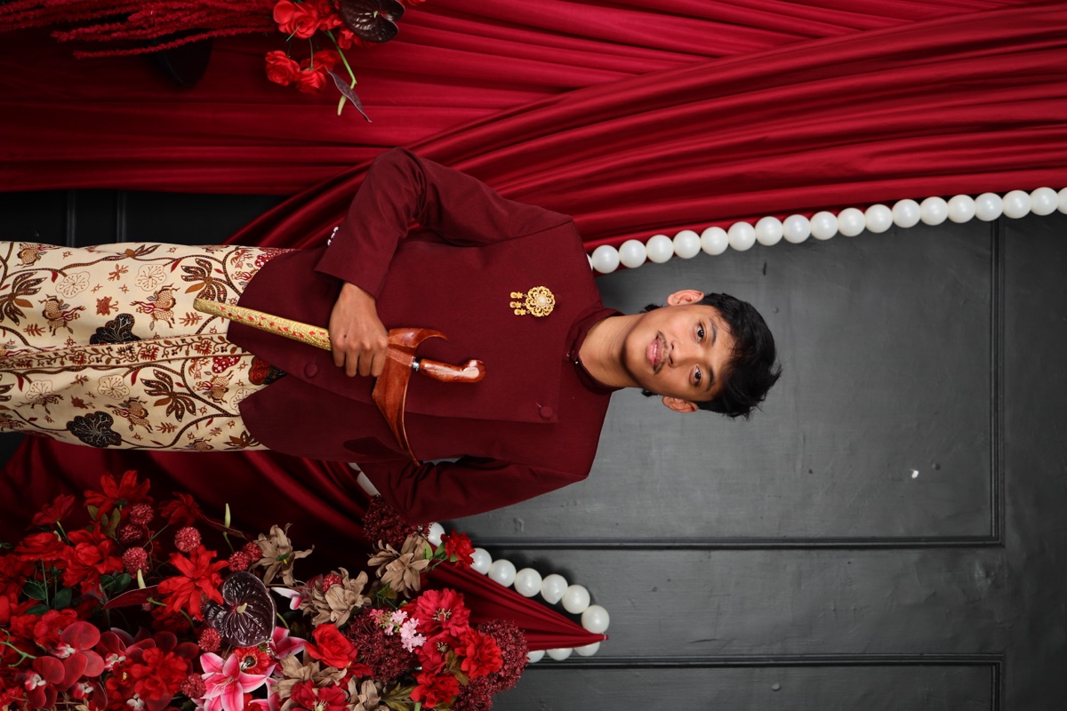 Kivlan mengenakan busana adat Jawa bernuansa burgundy